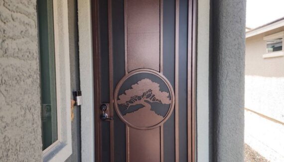 Beautiful bronze colored plasma cut screen door with a circle and tree design in the middle of the door.