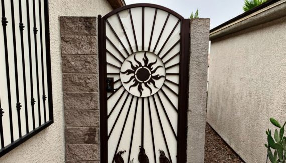 Wrought iron side gate with ornate sun and quail design in Las Vegas.