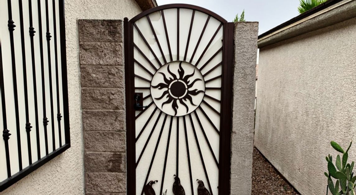 Wrought iron side gate with ornate sun and quail design in Las Vegas.