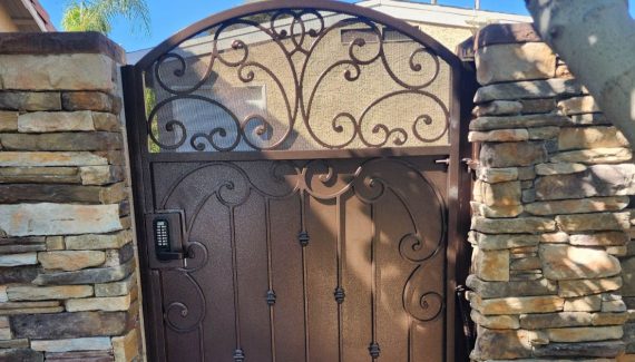 Wrought iron automated gate with brown finish and light solar screen.