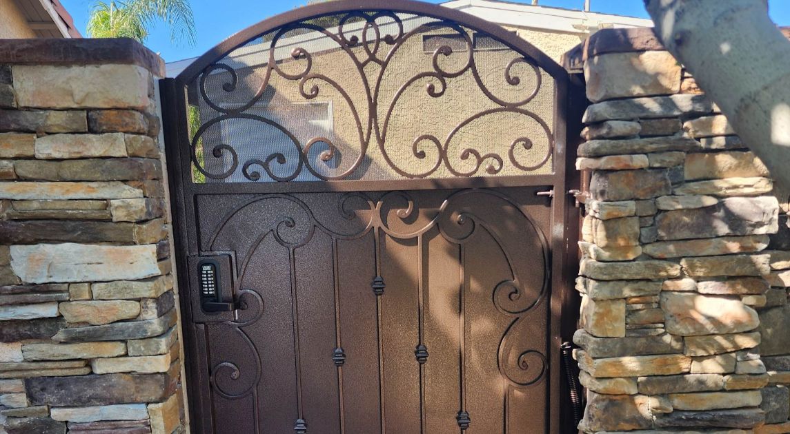 Wrought iron automated gate with brown finish and light solar screen.